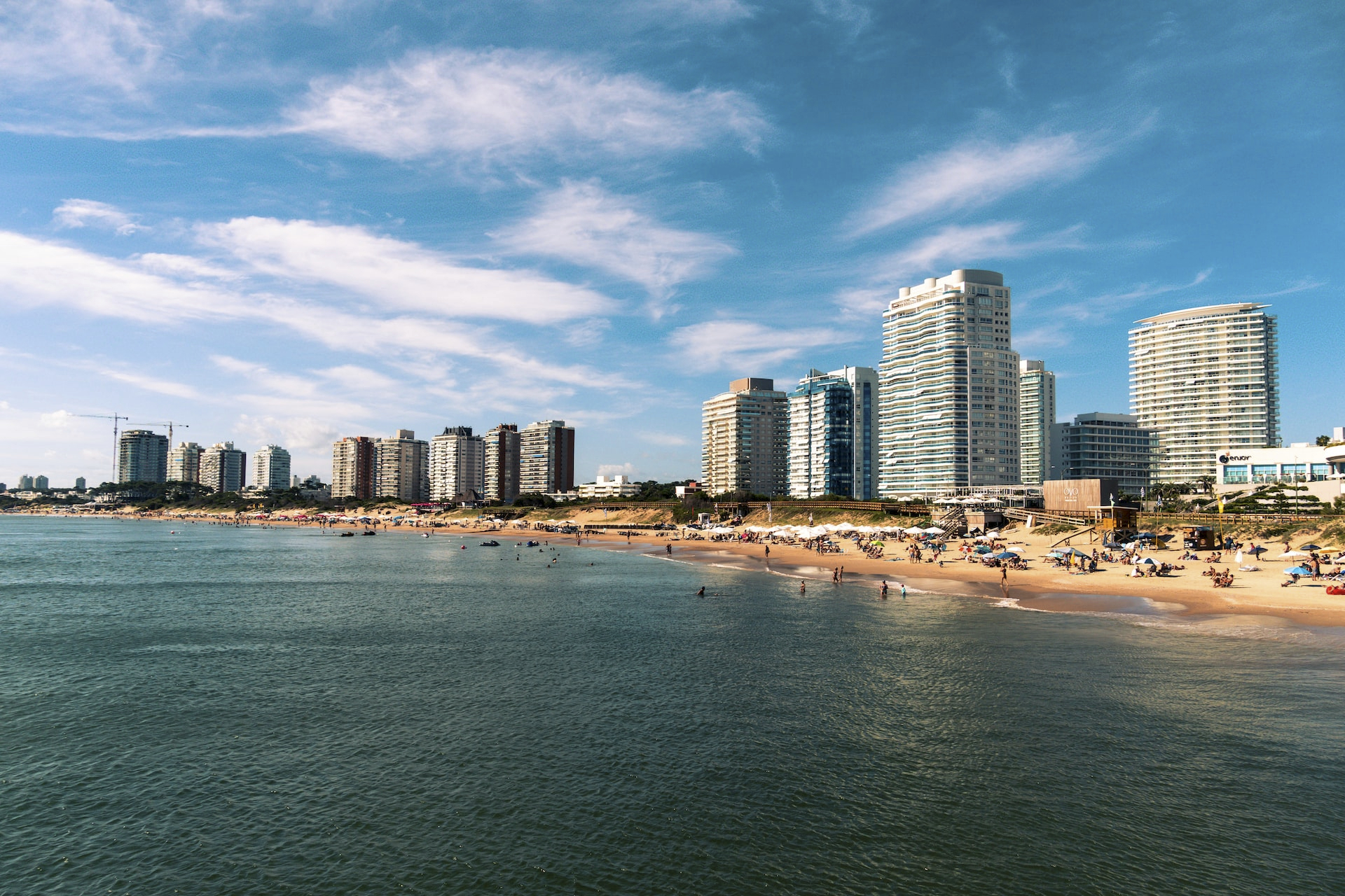 high rise buildings near sea under blue sky and white clouds during daytime